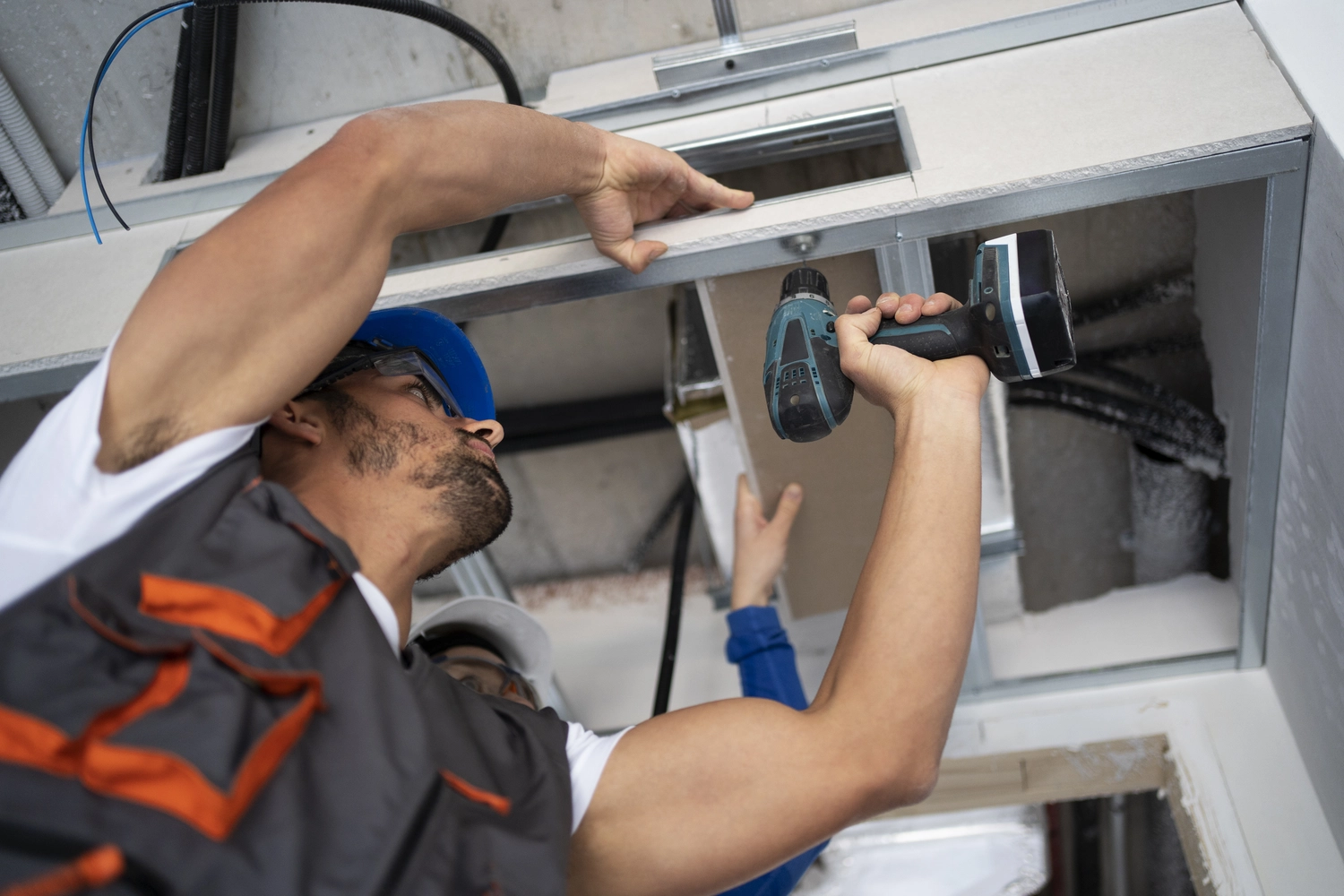 Elektro Wollmer GmbH - Innovative Klimatechnik - Reparaturtechniker repariert Außengerät der Klimaanlage.