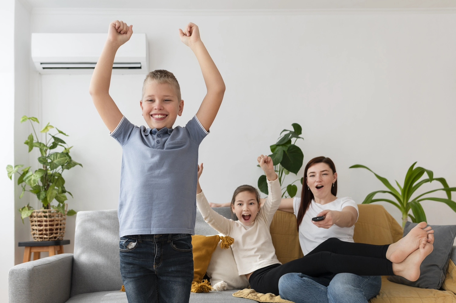 Elektro Wollmer GmbH - Innovative Klimatechnik - Glückliche Familie genießt die angenehme Temperatur im klimatisierten Zimmer.