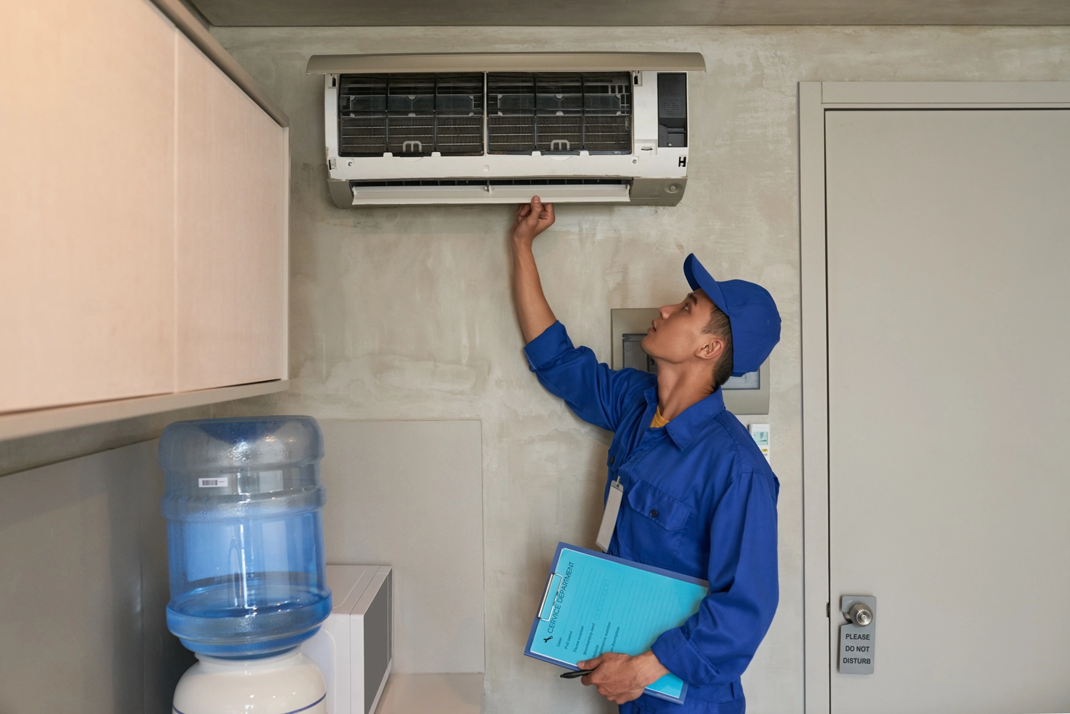 Elektro Wollmer GmbH - Innovative Klimatechnik - Eine Frau dreht die Flügel einer Klimaanlage